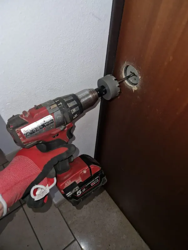 Foratura del cilindro con trapano per aprire una porta bloccata – fabbro al lavoro a Bologna