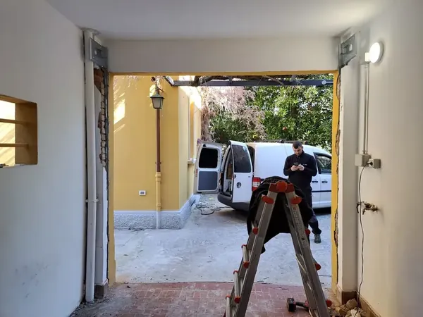 Tecnico al lavoro sul montaggio di una serranda da garage – riparazione serrande a Bologna